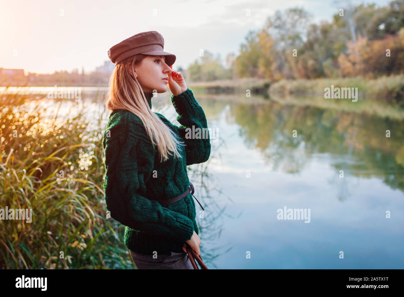 Otoño de moda moderna. Mujer joven vistiendo un suéter elegante traje y  sombrero por río. Ropa y accesorios Fotografía de stock - Alamy