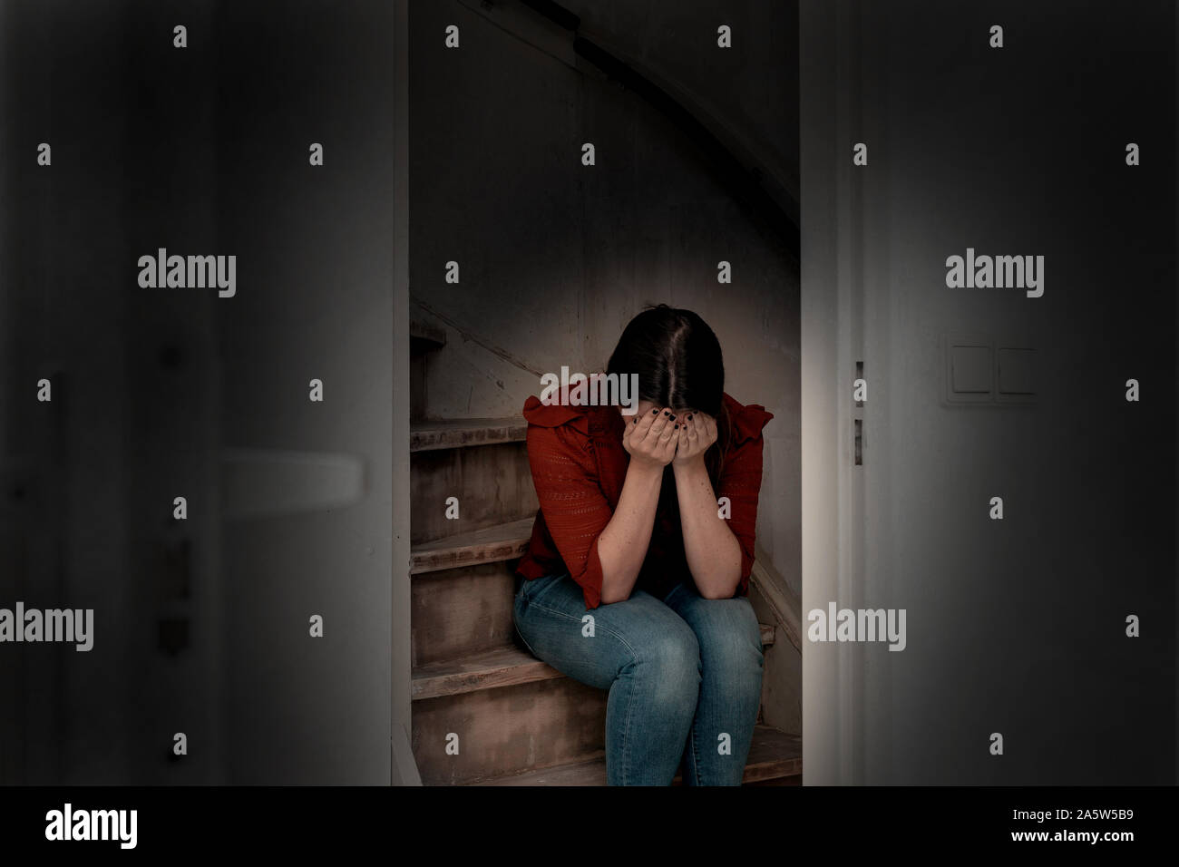 Mujer joven grita y en una escalera oscuridad, solitario triste y deprimida Chica sujetando su cabeza abajo Fotografía de stock - Alamy