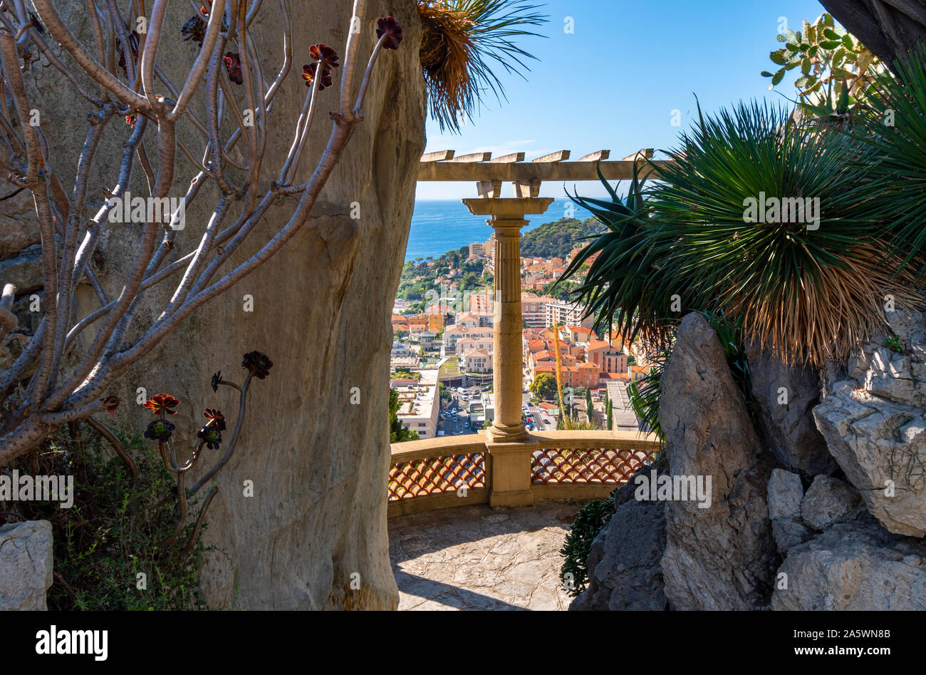 Vistas al Mar Mediterráneo y a la ciudad de Montecarlo, Mónaco, entre las columnas de la terraza en la ladera de exóticos jardines. Foto de stock