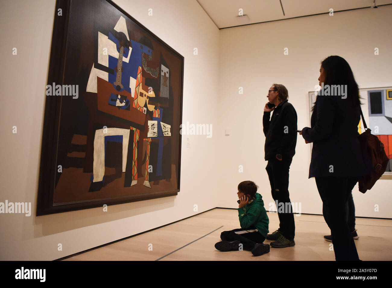 Nueva York, Estados Unidos. 22 Oct, 2019. Los visitantes ver la pintura  tres músicos del artista español Pablo Picasso en el Museo de Arte Moderno  (MoMA) de Manhattan de Nueva York, Estados