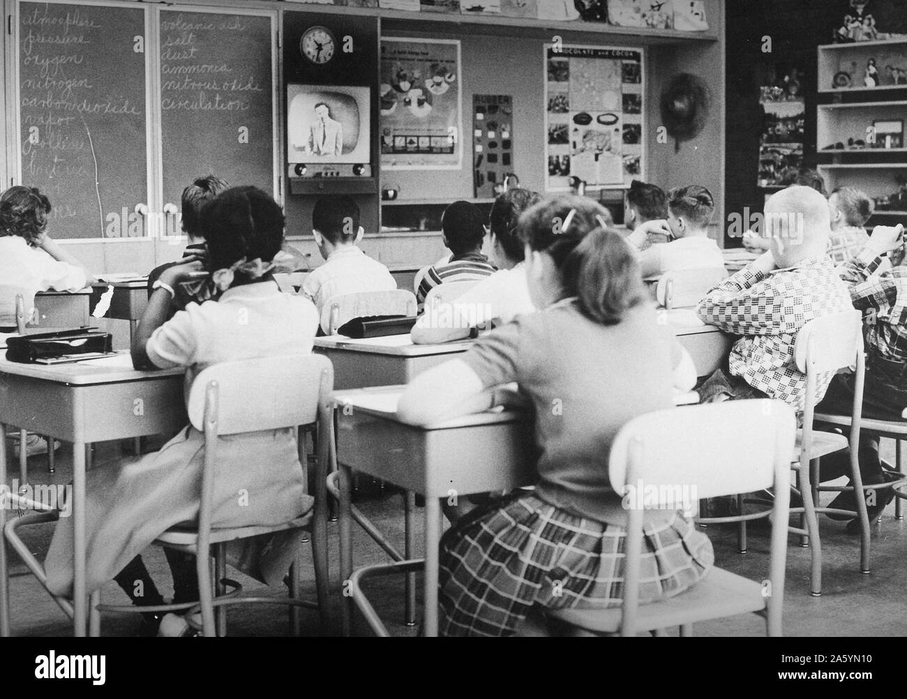 La televisión usada para impartir clases en una clase integrada de blancos y afro-americanos escolares. Circa 1967 Foto de stock