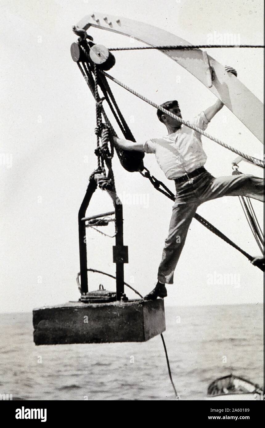 Geólogo marino en una encuesta; siembra un hidrófono ancla con el cable conectado. El hidrófono se capta el sonido de un hombre hizo explosión submarina. Levantamiento geodésico; Cabo Blanco, Oregon, USA 1924 Foto de stock