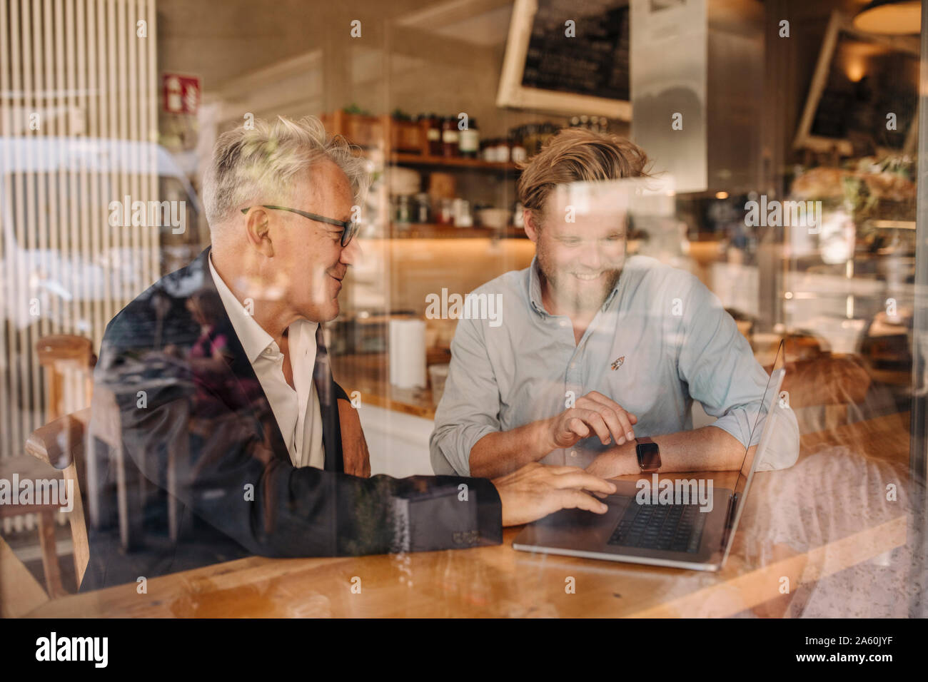 Dos empresarios sonriente con laptop reunión en un café Foto de stock