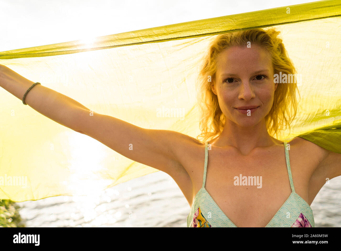Retrato de mujer joven sosteniendo un paño en un lago Foto de stock