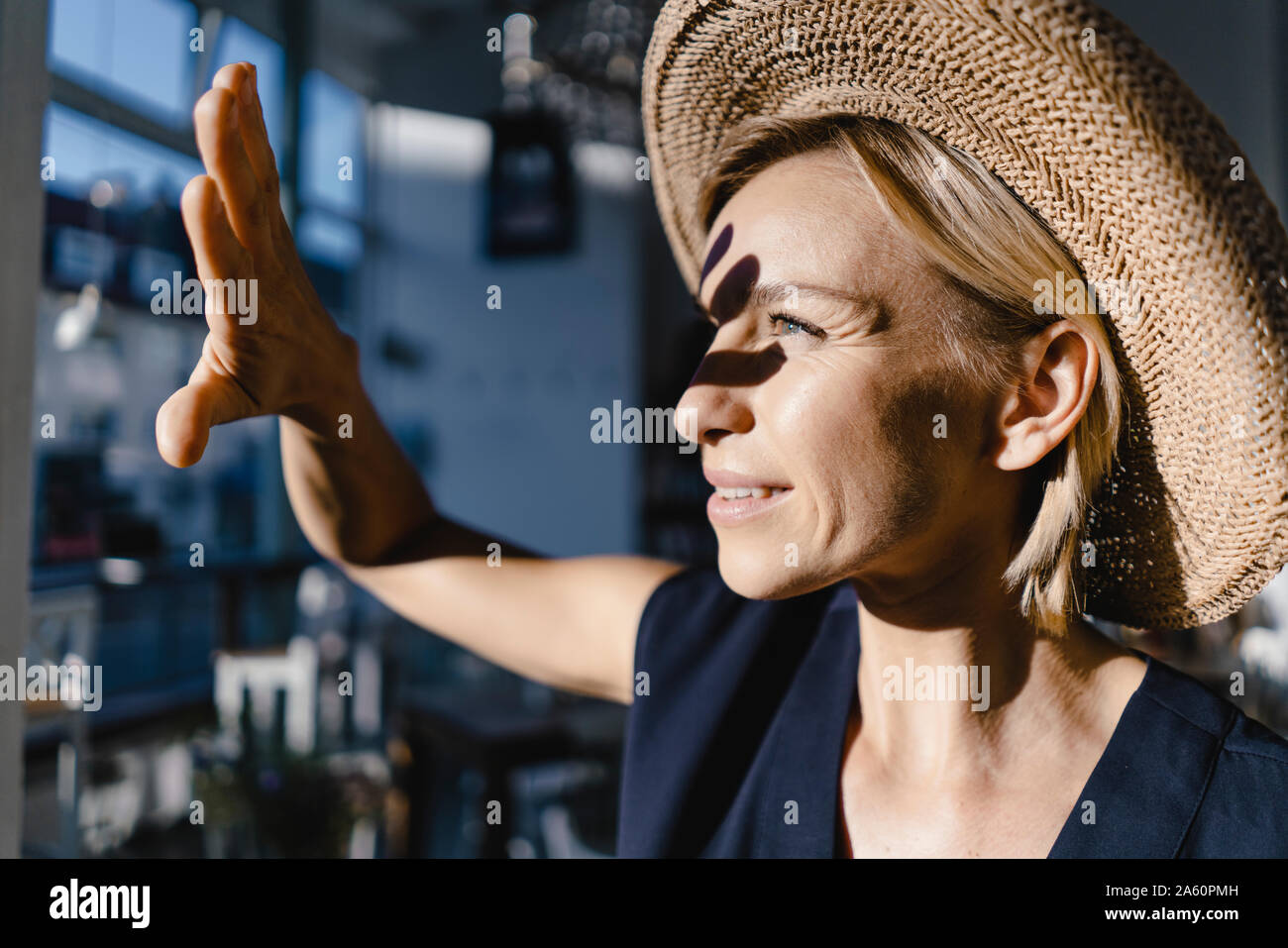 Mujer vistiendo staw hat, protegiendo su rostro del sol Foto de stock
