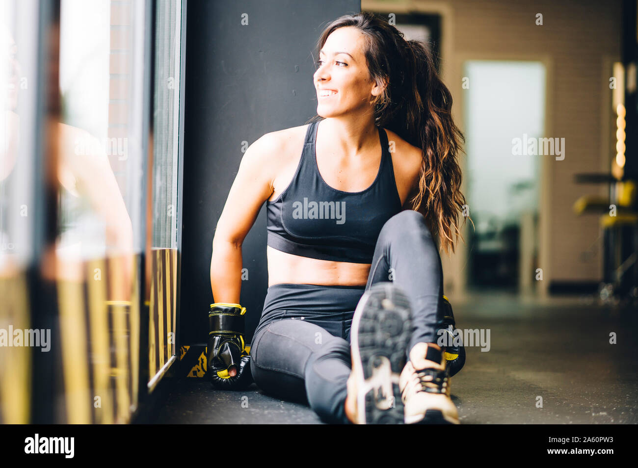 Boxer hembra sonriente descansa después del entrenamiento de boxeo Foto de stock