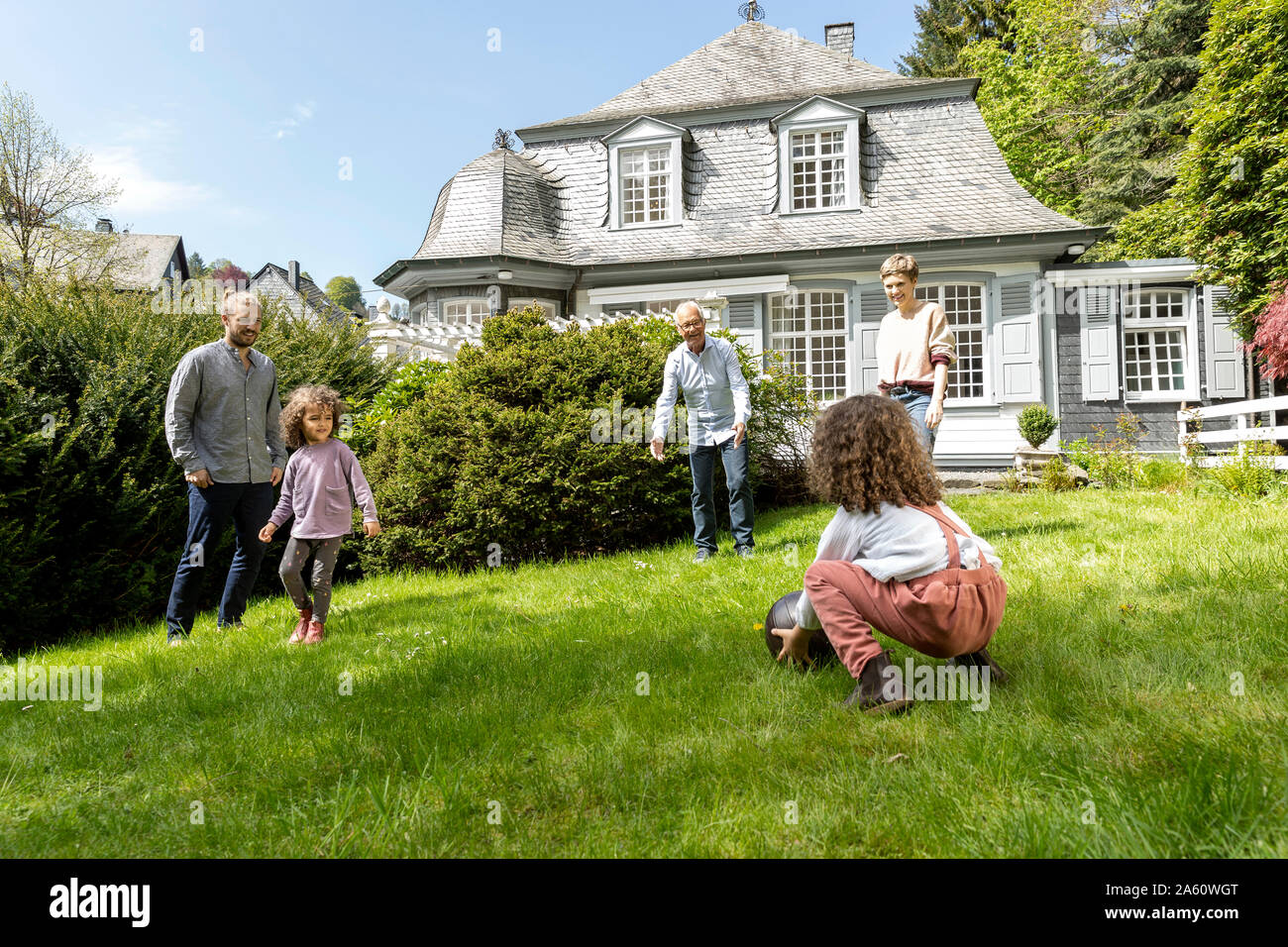 Familia feliz jugando al fútbol en el jardín Foto de stock