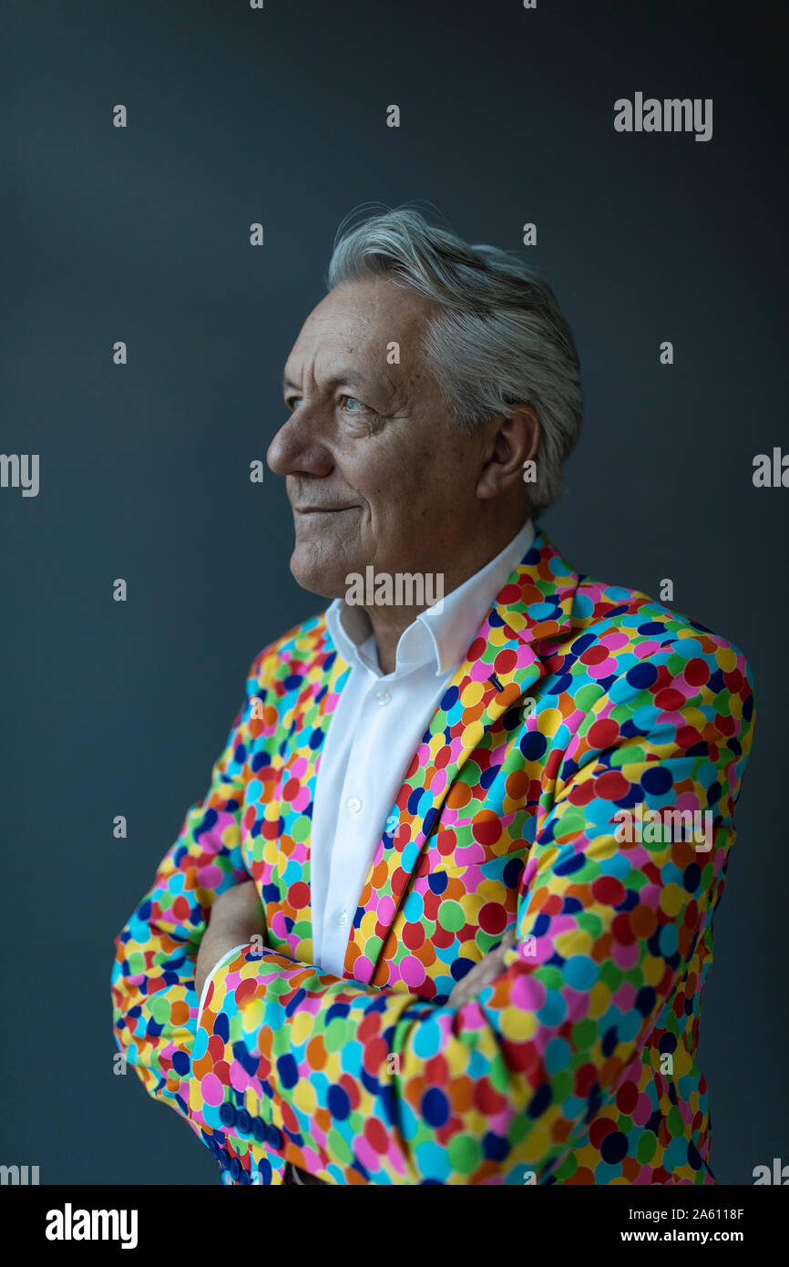 Empresario Senior vistiendo coloridos chaqueta deportiva mirando lejos Foto de stock