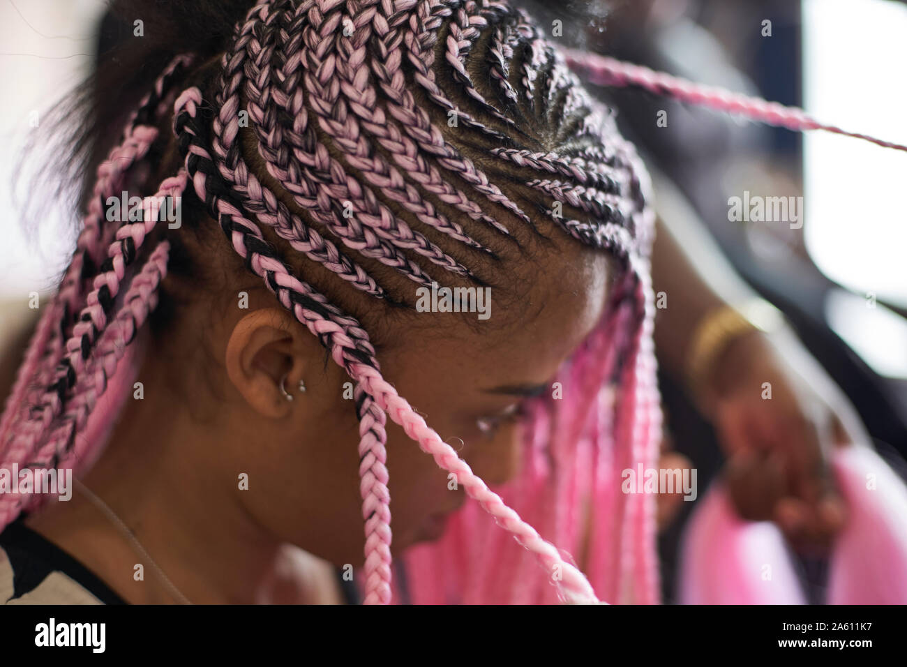 Mujer joven con trenzas, rosa de cerca Fotografía de stock - Alamy