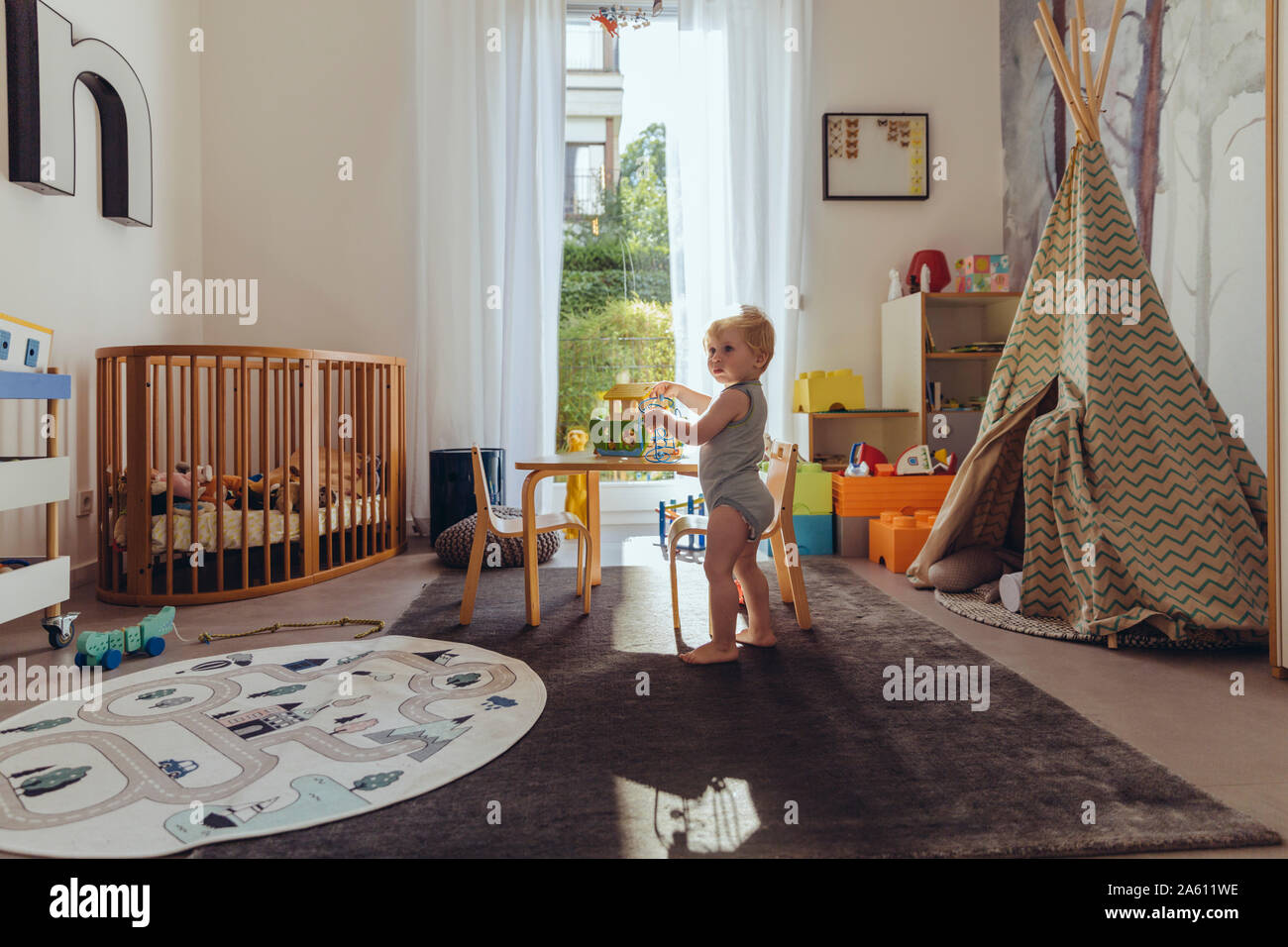 Baby Boy jugando en su vivero Foto de stock