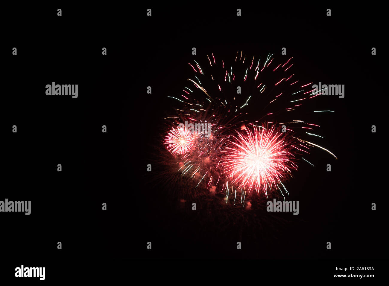 Fotografiar fuegos artificiales en el cielo de la noche con un tiempo de exposición y el negro como color de fondo de imagen de alta calidad para pc buenos antecedentes e impresiones artísticas. Foto de stock