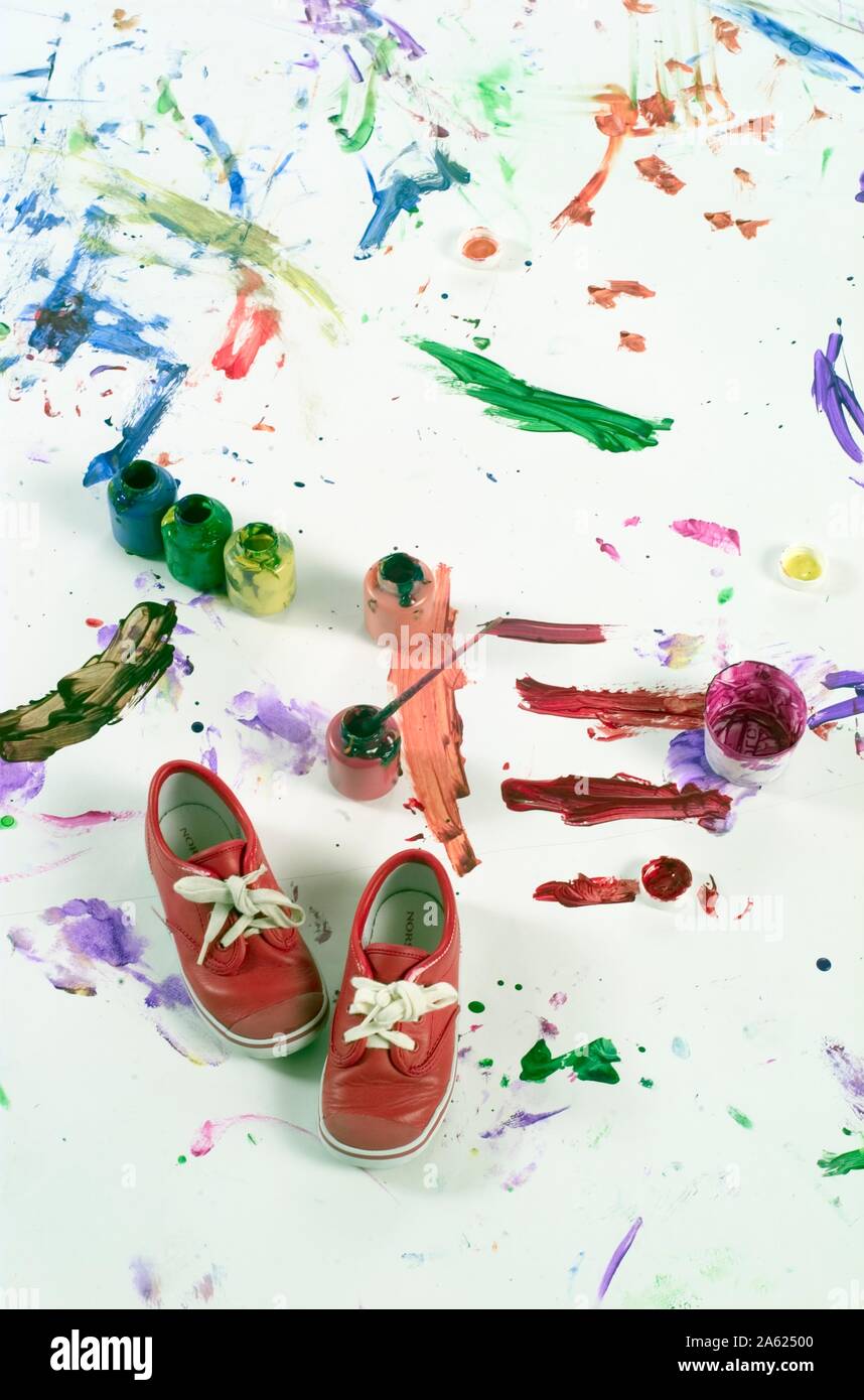 Children's sobrantes de pintura sobre un fondo blanco con restos sneakers Foto de stock