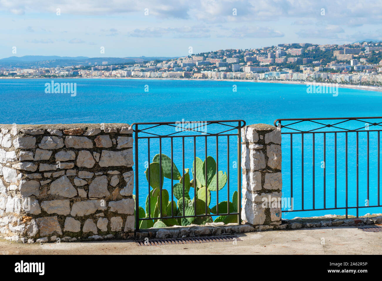 La luz del sol golpea un Mediterráneo cactus con el azul de la Bahía de Los Ángeles, la playa, el mar y la ciudad de Niza Francia desde un mirador en el Parque de la Colina del Castillo. Foto de stock