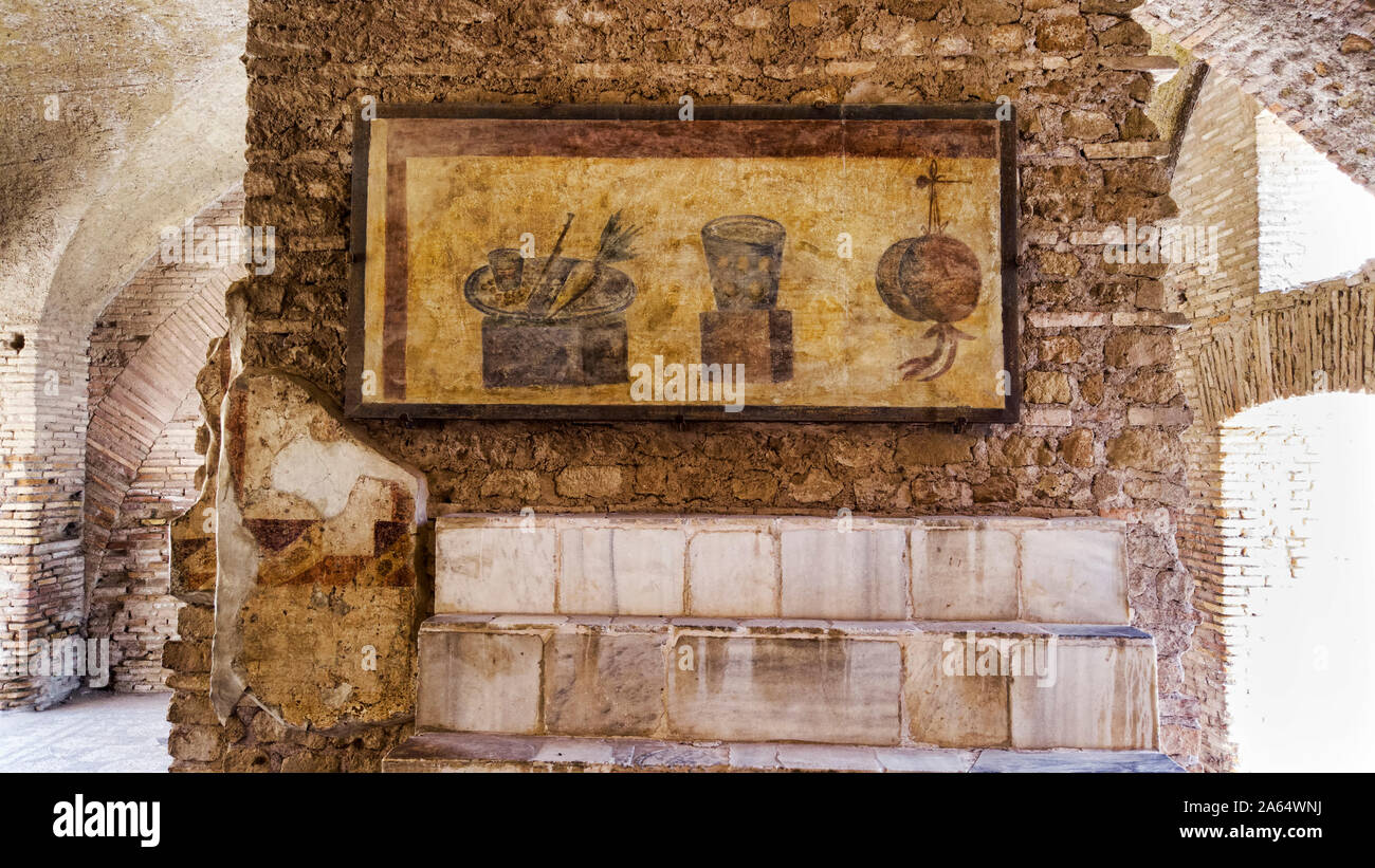 Excavaciones arqueológicas del imperio romano en Ostia Antica con el interior de la vivienda y el Termopolio s repisa de mármol coronada con decoración Foto de stock