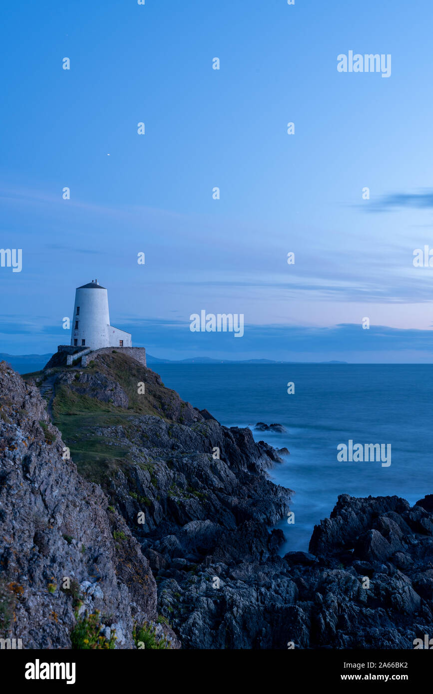 El faro de la isla Llanddwyn, Twr Mawr en Ynys Llanddwyn en Anglesey, Gales del Norte en la hora azul Foto de stock