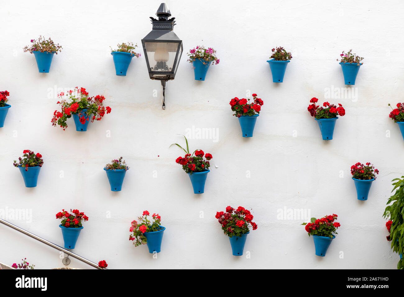 Una pared decorada con flores y jarrones azules, Córdoba, Andalucía, España. Foto de stock