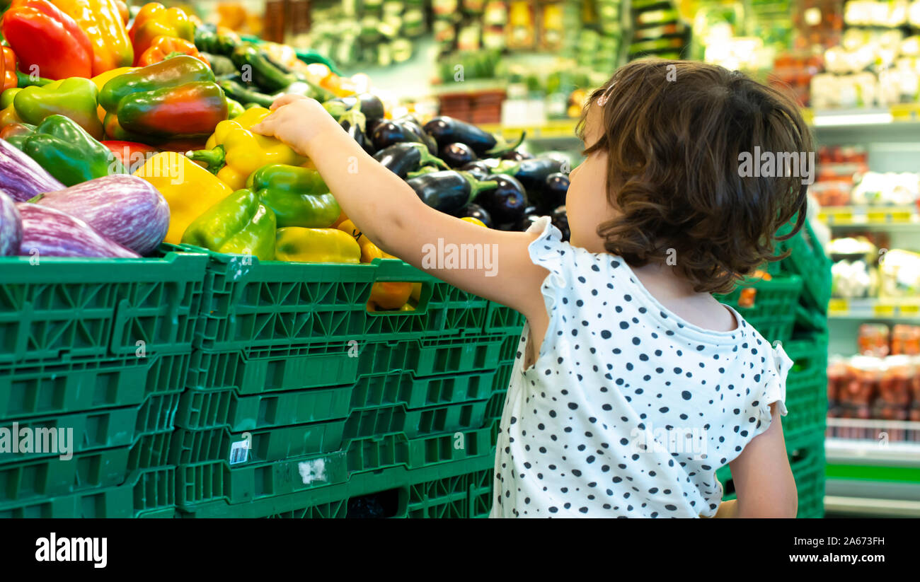 Compras infantil pimientos en el supermercado. Concepto para comprar frutas  y verduras en el hipermercado. Niña mantenga cesta de la compra Fotografía  de stock - Alamy