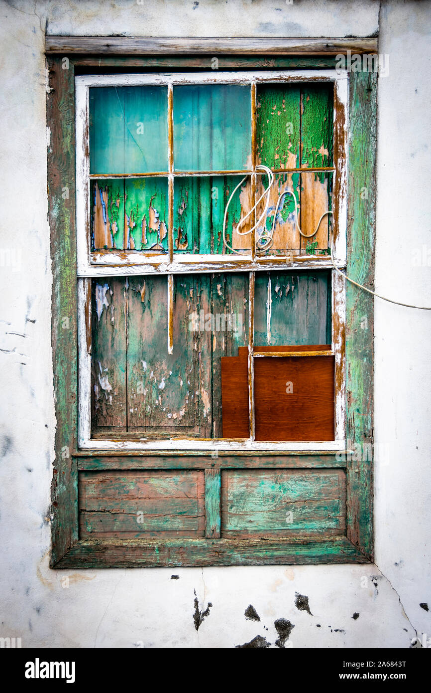 Antigua ventana abandonados con el desprendimiento de la pintura y el clima de madera desgastada. Foto de stock