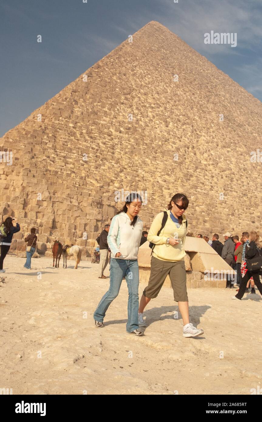 Dos estudiantes de la Universidad Johns Hopkins, afuera en un día soleado, alejándonos de una pirámide, con turistas y ponis visibles en el fondo, en Giza, Egipto durante un programa de estudios en el extranjero, 7 de enero de 2008. Desde el Homewood Fotografías. () Foto de stock