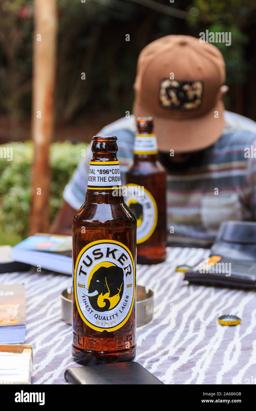 Nairobi, Kenya, 11 de julio de 2017 - El Turista disfruta de la cerveza local Tusker Foto de stock