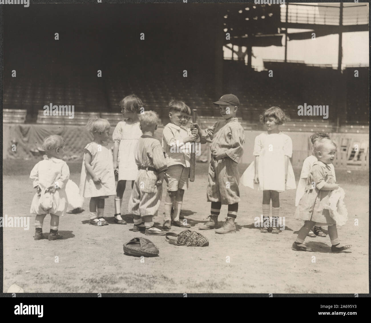Los muchachos y muchachas en el campo de béisbol en un estadio de grandes ligas Foto de stock