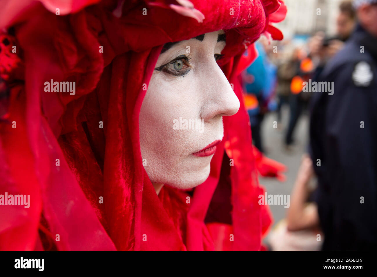 Londres, 10 de octubre de 2019, la extinción rebelión grupo en trajes rojos de policía rodean preparando la detención acivists que han encadenado a una estructura de madera en la carretera junto a Trafalgar Square. Foto de stock