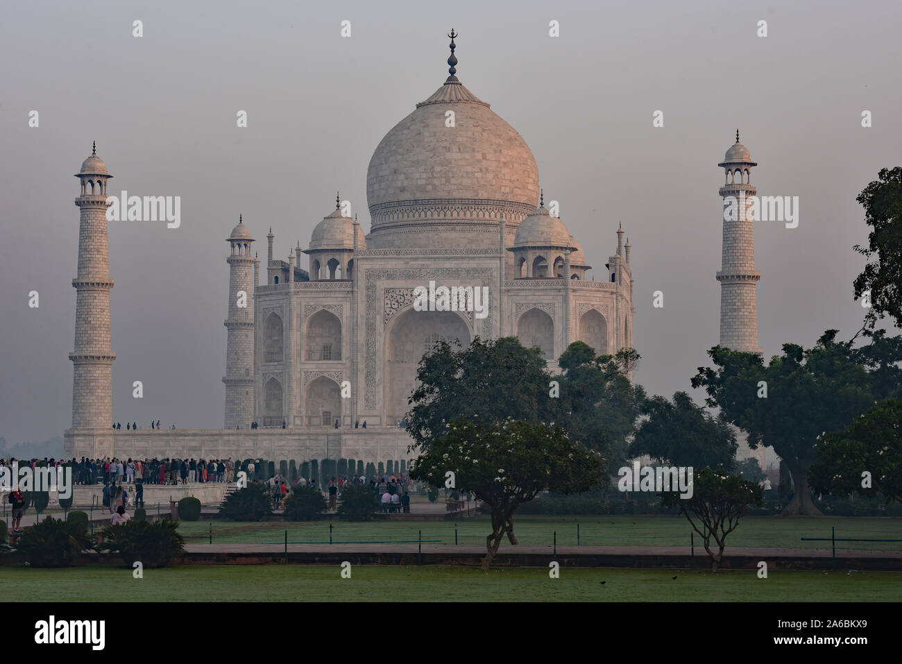 Niebla por la mañana temprano envuelve el Taj Mahal como multitudes de turistas montar, esperando el sol, Agra, India, Asia Central. Foto de stock