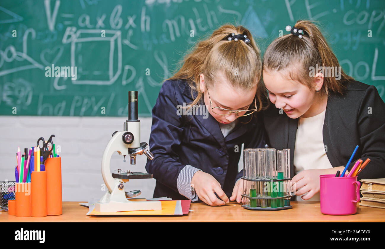 Conocimientos básicos de química. Los alumnos cute girls utilizar tubos de ensayo con líquidos. Experimento de química concepto. Medidas de seguridad para garantizar la seguridad de la reacción química. Realizar estudio química interesante. Foto de stock
