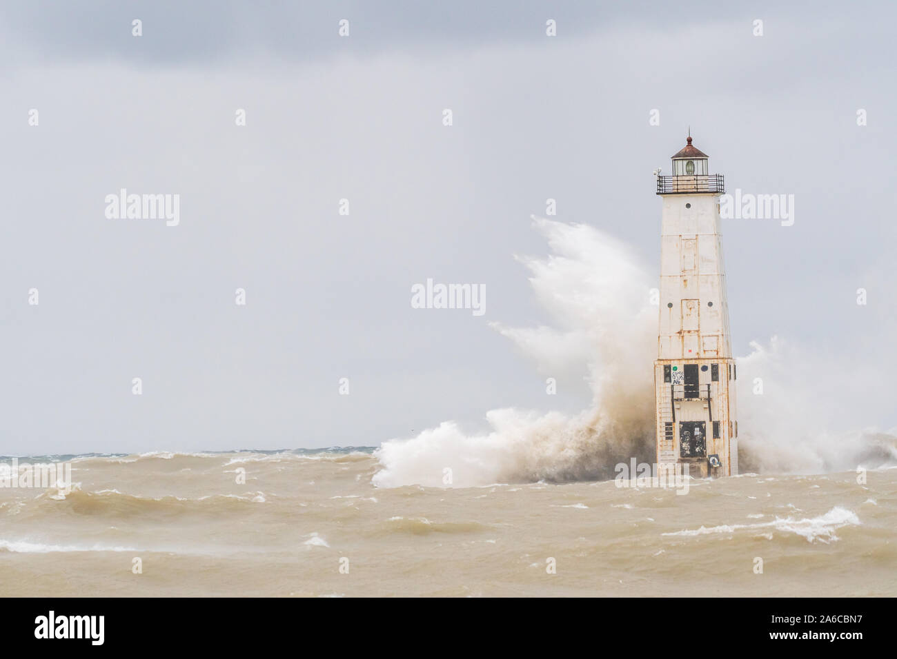 Las olas rompen en la escollera norte de Frankfort Faro en Frankfort, Michigan, Estados Unidos. Foto de stock