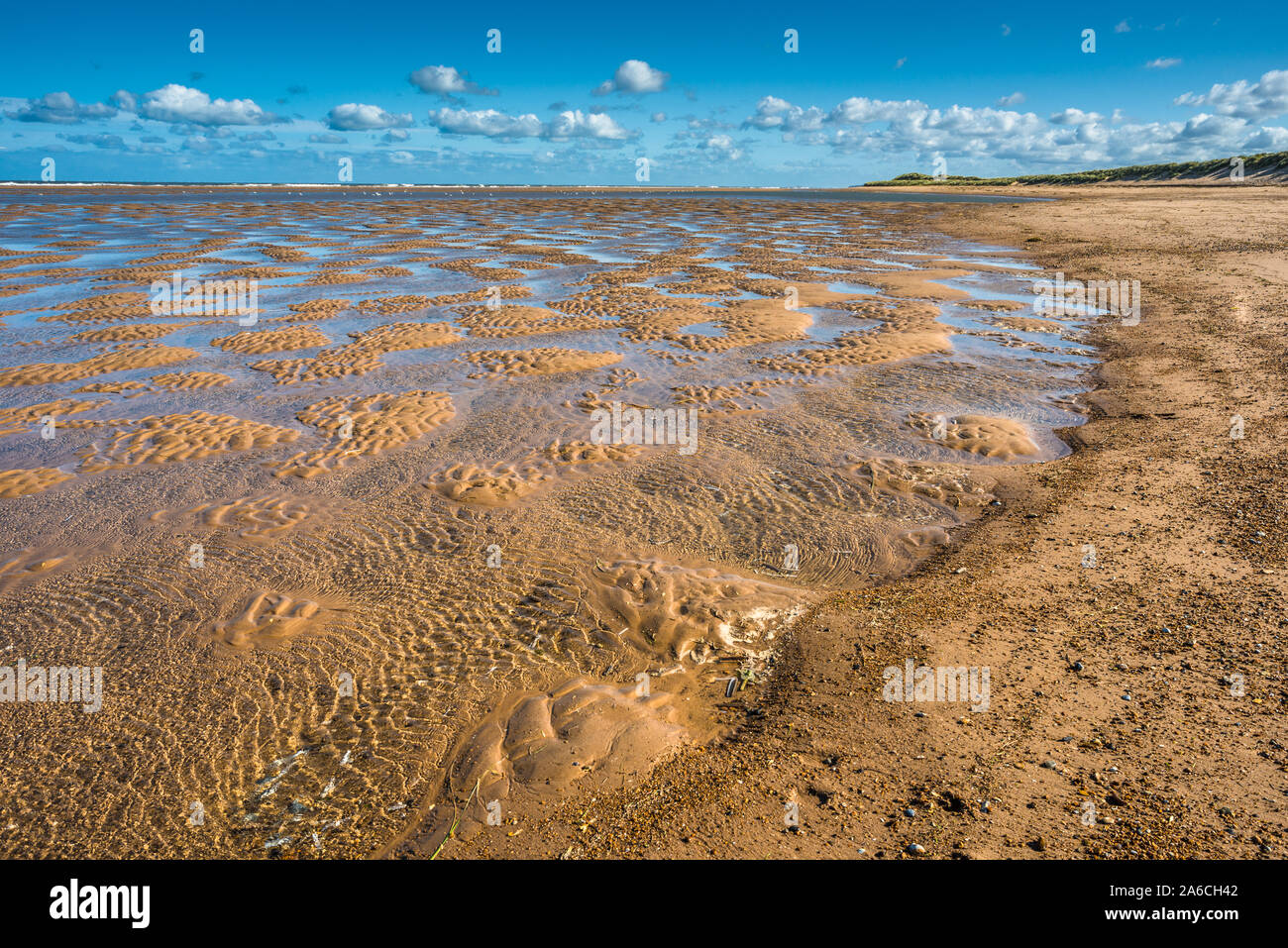 Patrones hechos por charcas de marea de agua en marea baja en la playa Burnham Overy Staithe en Holkham Bay, costa norte de Norfolk, East Anglia, Inglaterra, Reino Unido. Foto de stock