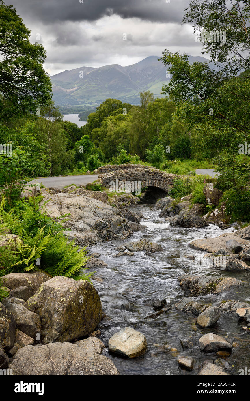 Las viejas piedras Ashness puente sobre Barrow Beck que fluye al lago Derwentwater y Keswick bajo Skiddaw Mountain Lake District Inglaterra Foto de stock