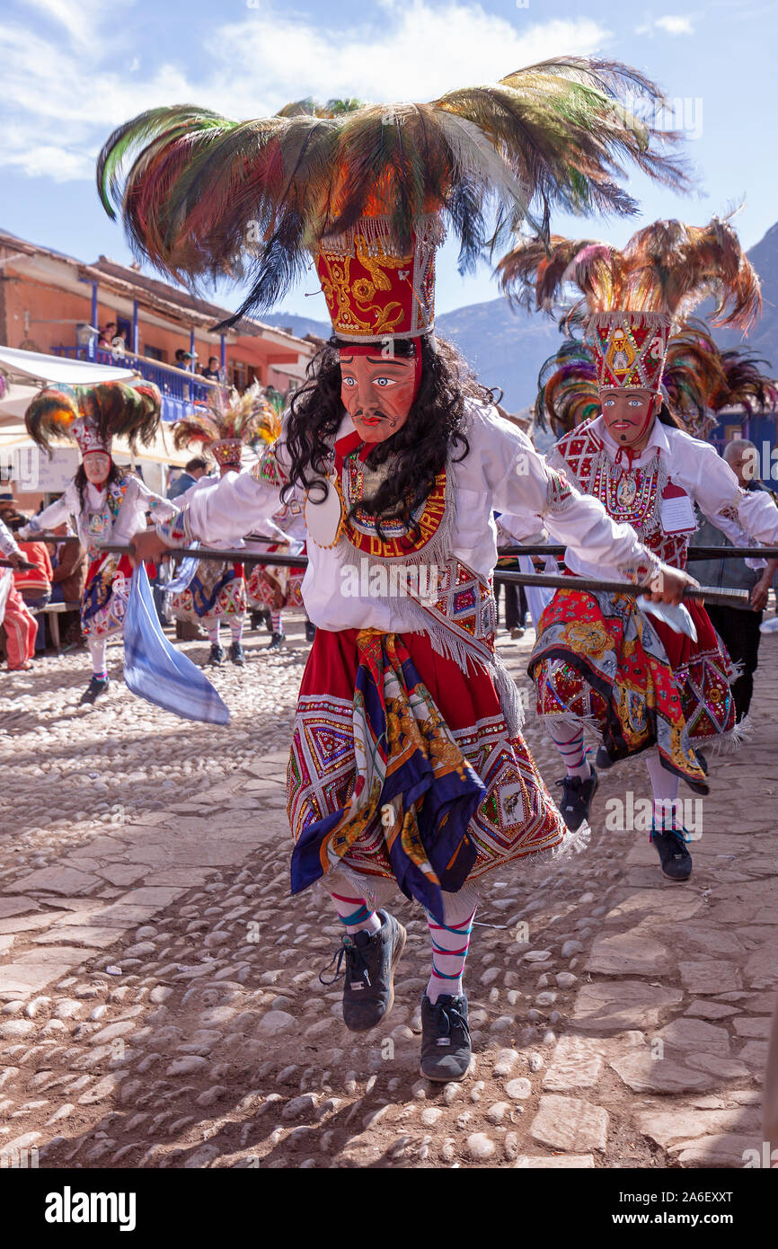 Las personas que portaban máscaras están bailando en un tradicional desfile de disfraces en Pisac, Perú. Foto de stock