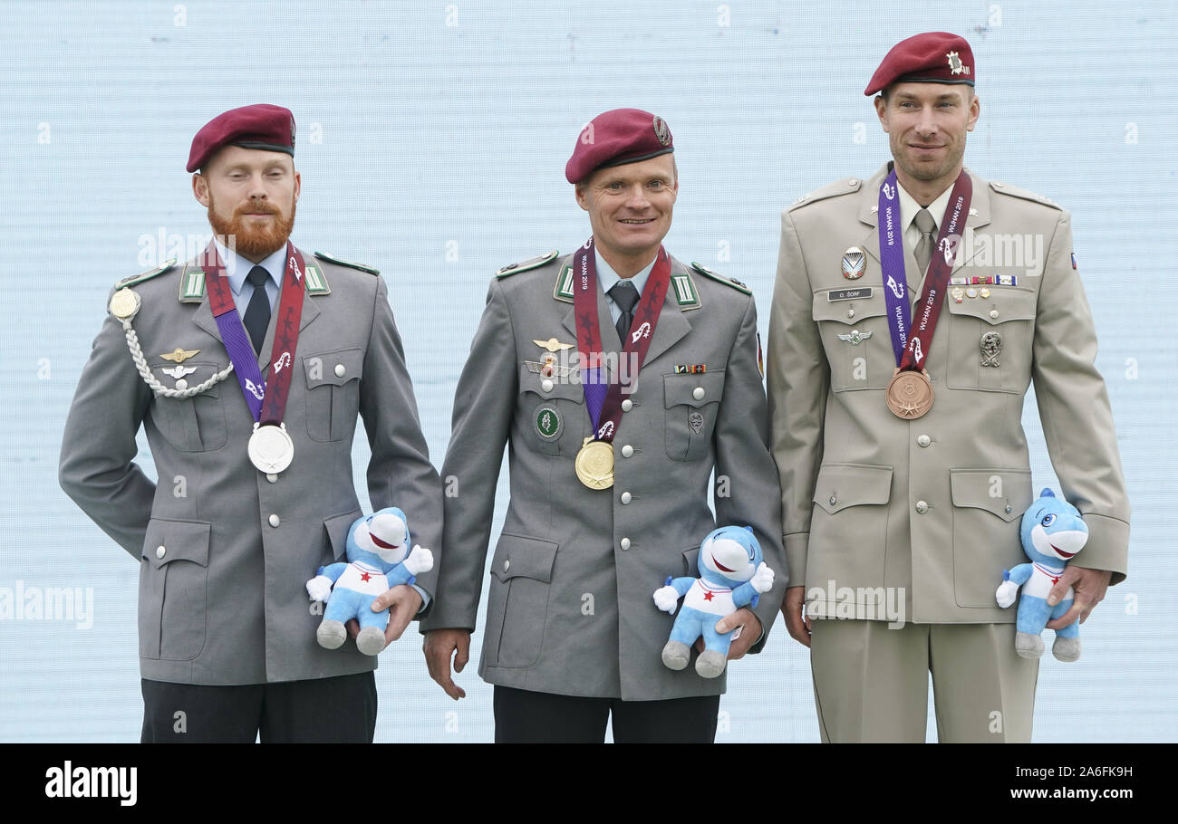 Wuhan, China, en la provincia de Hubei. 26 Oct, 2019. Wuhan, China. 26 de octubre de 2019. La medallista de oro Stefan Wiesner (C) de Alemania, medallista de plata Elischa Weber(L) de Alemania y medallista de bronce Sorf Oldrich de la República Checa asistir a la ceremonia de entrega de los hombres de la general individual de paracaidismo en la séptima CISM Juegos Mundiales Militares en Wuhan, capital de la provincia de Hubei en China central, Octubre 26, 2019. Crédito: Cheng Min/Xinhua/Alamy Live News Crédito: Xinhua/Alamy Live News Foto de stock