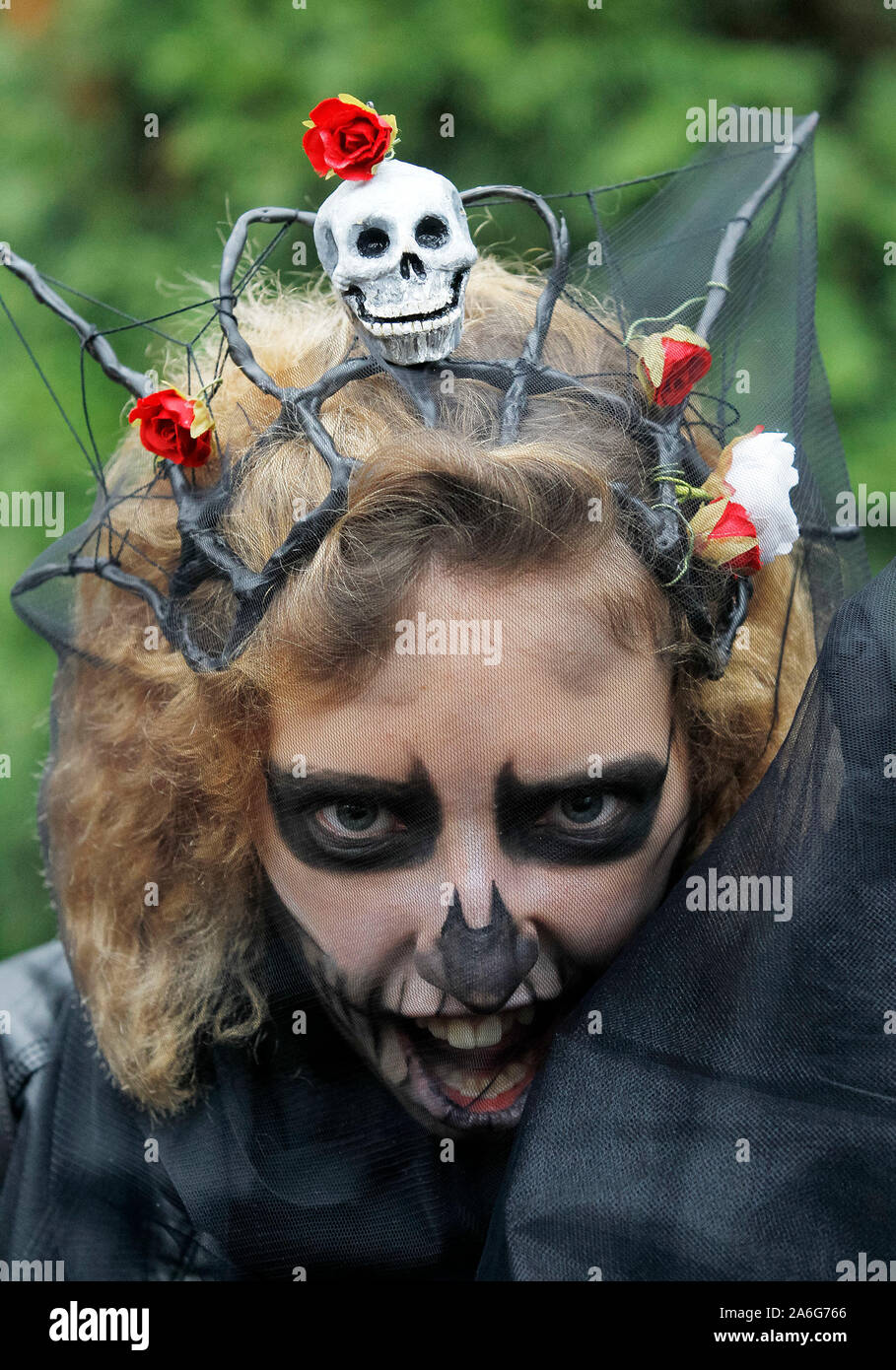 Una chica que llevaba el maquillaje y un traje Zombie asiste al desfile de Halloween en de zombis, escalonados a través del interior de la ciudad en busca de cerebros frescos Una chica que llevaba el maquillaje y un traje Zombie asiste al desfile de Halloween en de zombis, escalonados a través del interior de la ciudad en busca de cerebros frescos