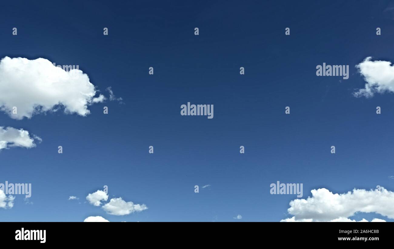 Cielo azul profundo, hinchadas nubes blancas que rodean el área de texto central grande Foto de stock