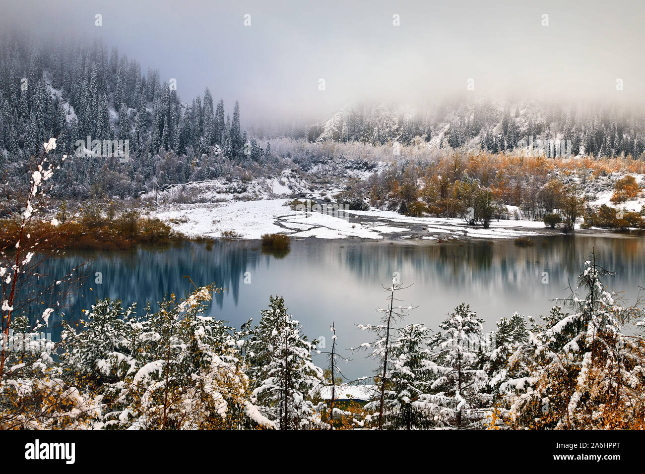 Hermosa vista a la montaña el lago Issyk con amarillo árboles en otoño con nieve en Kazajstán, Asia Central Foto de stock