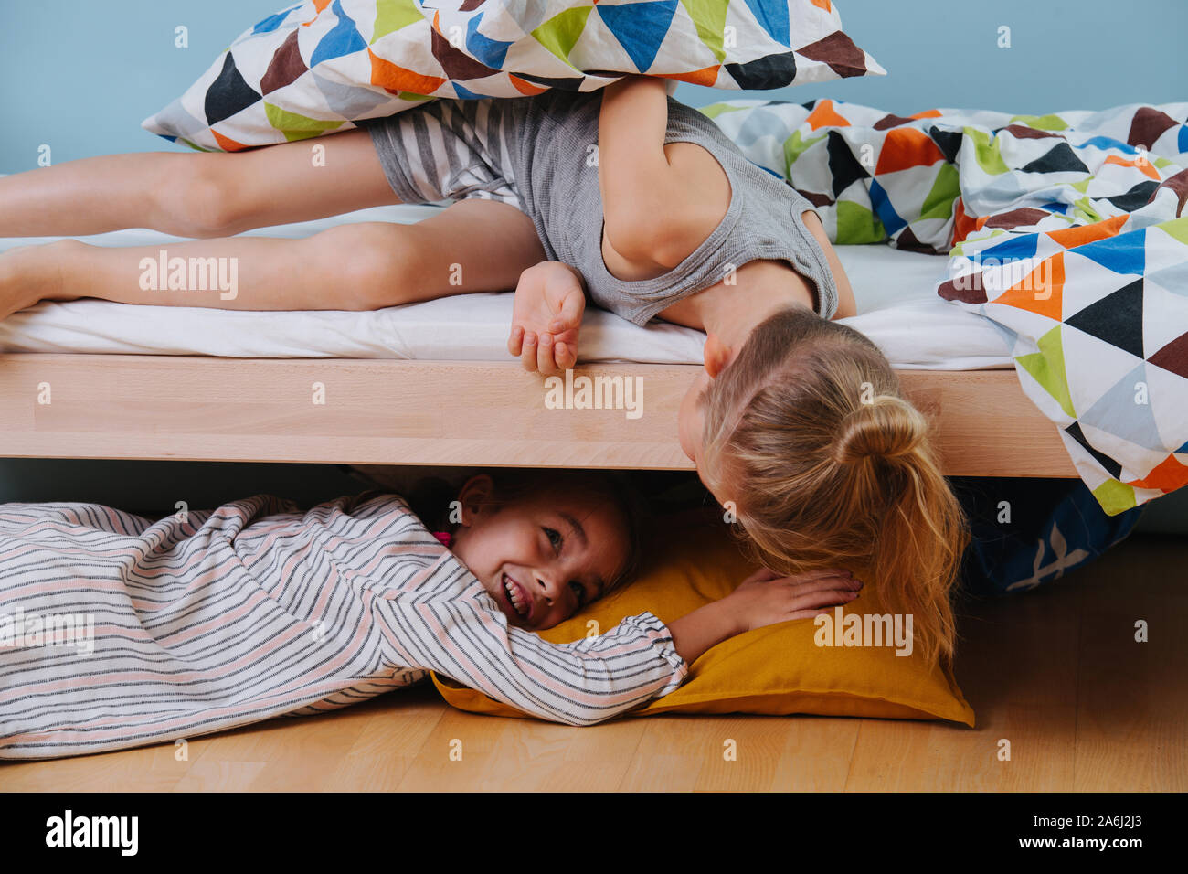 Niño y niña jugando en el dormitorio. Chica que yacía bajo la cama, el  muchacho mira Fotografía de stock - Alamy