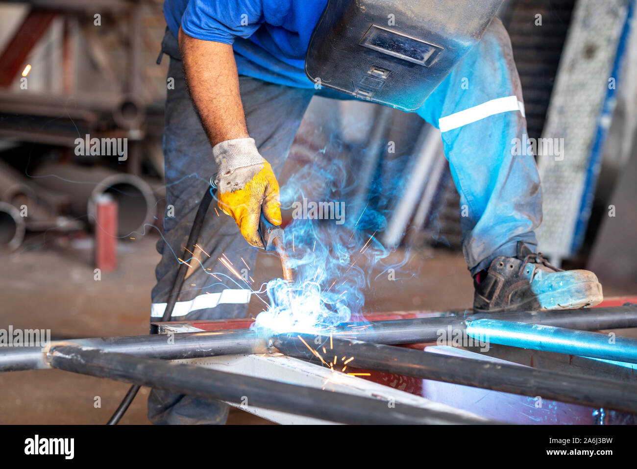 Obrero metalúrgico es soldar metales con protección de él mismo. Foto de stock