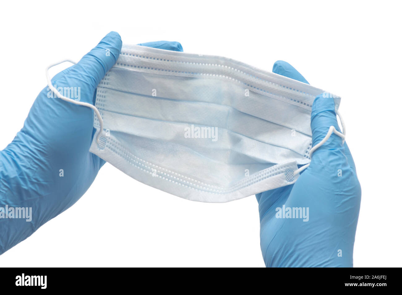 Manos enguantadas preparar máscara de control de infección para ser usado por profesionales de la medicina. Foto de stock