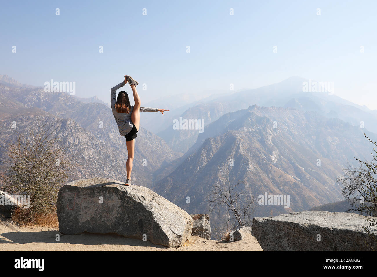 Las hembras jóvenes se involucra en pose de yoga increíble en el pintoresco entorno de montaña. Foto de stock