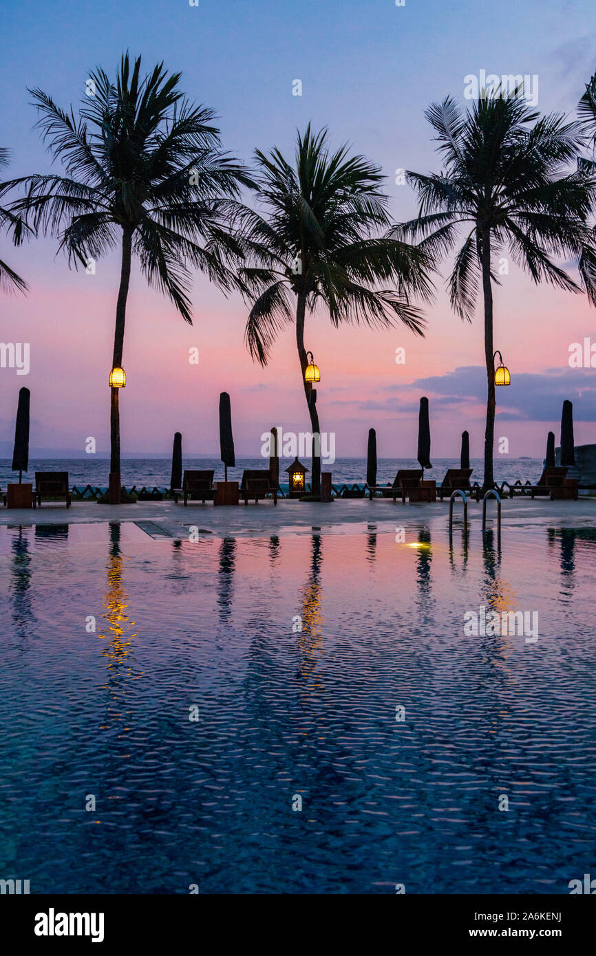 Hotel de lujo con piscina con palmeras y el Océano Índico al anochecer, Candidasa, la parte oriental de Bali, Bali, Indonesia, en el sudeste de Asia, Asia Foto de stock
