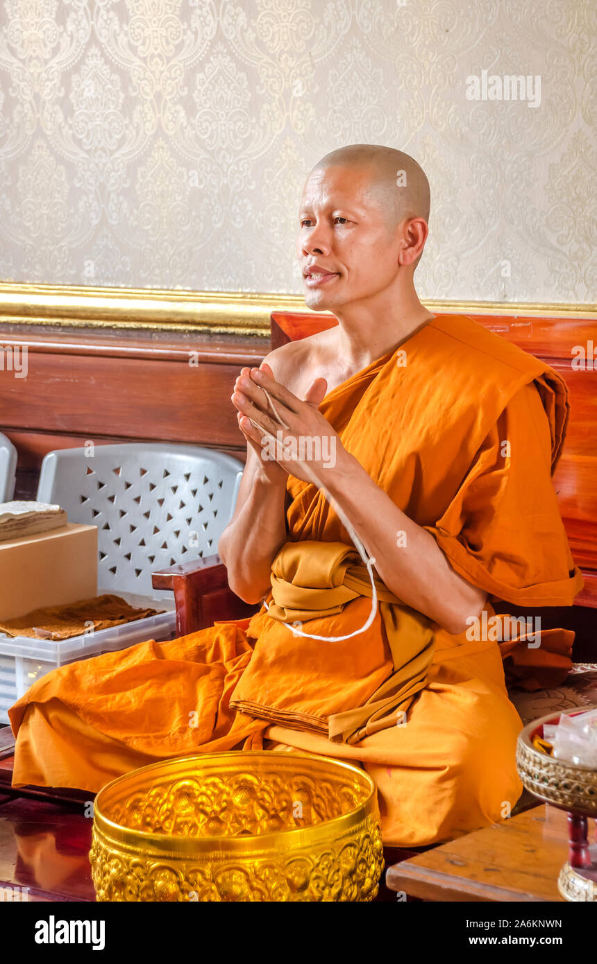 BANGKOK, TAILANDIA - Diciembre 22, 2018: el monje budista luciendo vestidos de azafrán manos plegada, orando en el templo Wat Traimit, Chinatown, Bangkok. Foto de stock