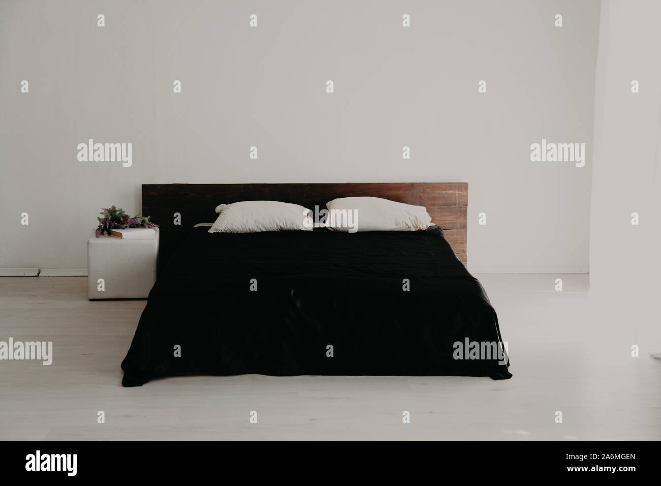 Blanco interior dormitorio y cama con sábanas negras Fotografía de stock -  Alamy