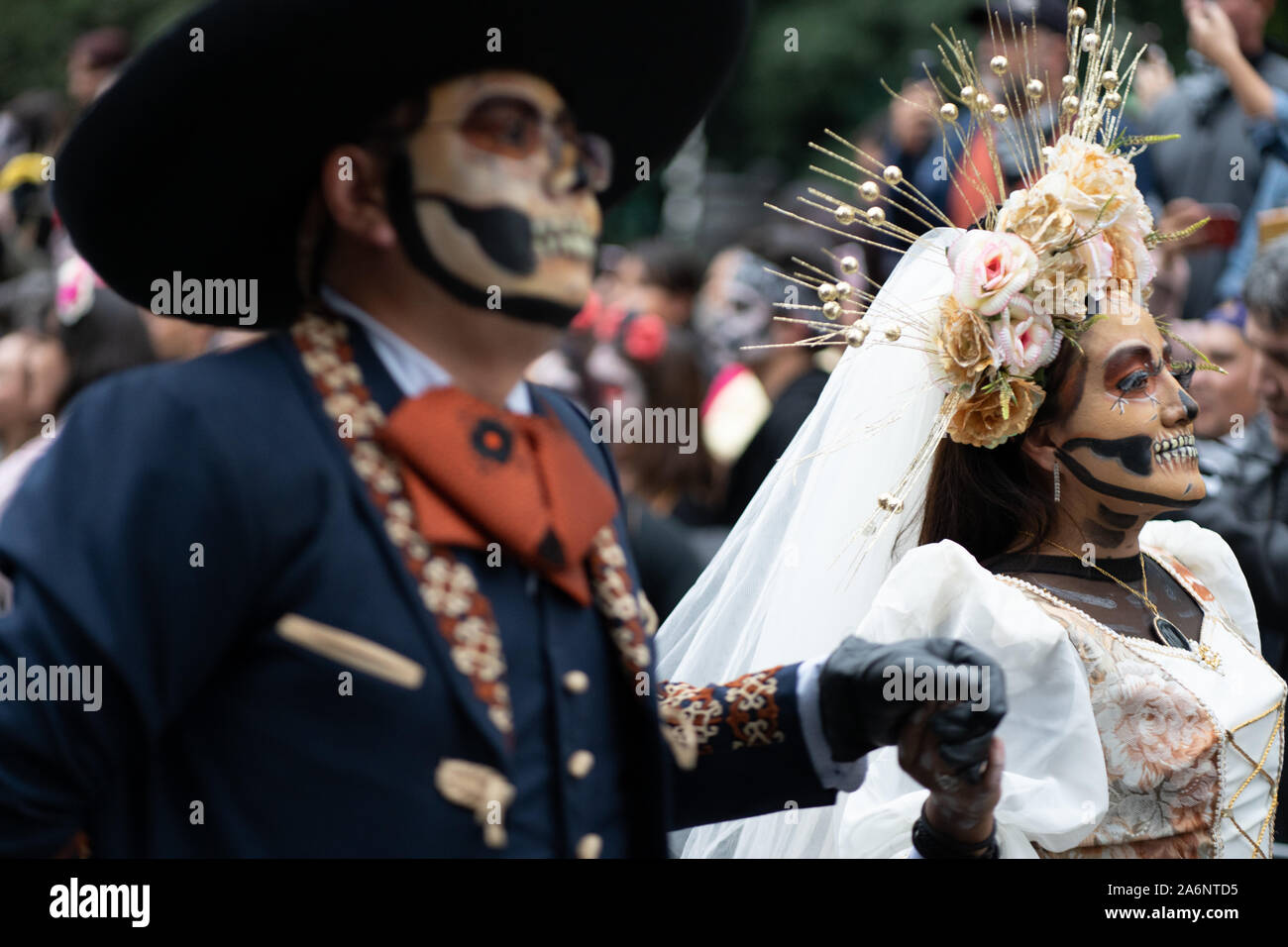 Ciudad de México, México. 26 Oct, 2019. Una mujer vestida de novia es  acompañado en el desfile durante la Catrina Festival. Miles de personas  salieron a las calles de la Ciudad de