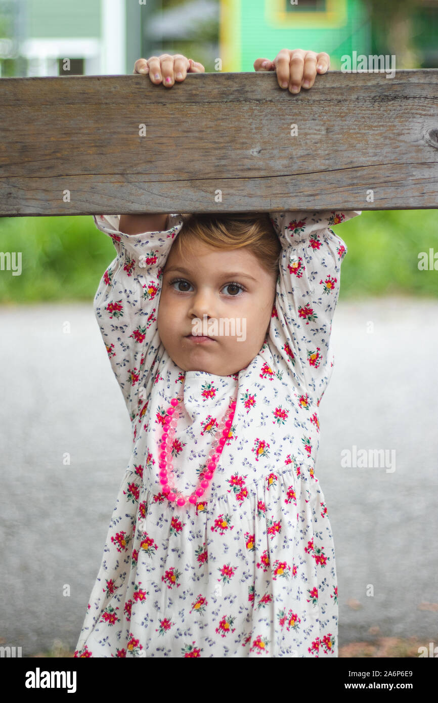 Niña de 4-5 años jugando por ella y haciendo una cara en la cámara Foto de stock