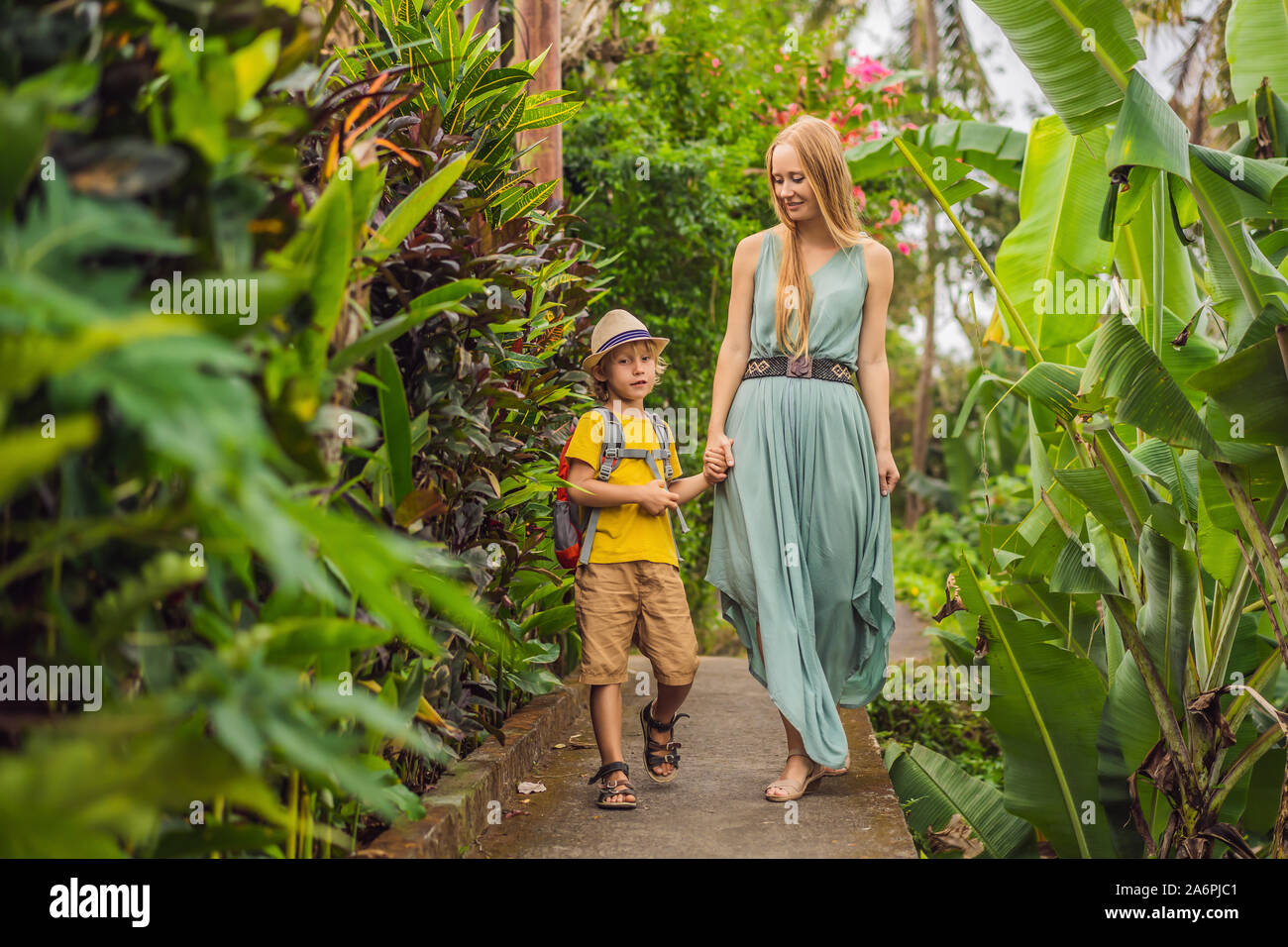 Madre e hijo a turistas en Bali paseos a lo largo de las estrechas calles acogedoras de Ubud. Bali es un destino turístico popular. Viajar a Bali concepto. Viajar Foto de stock