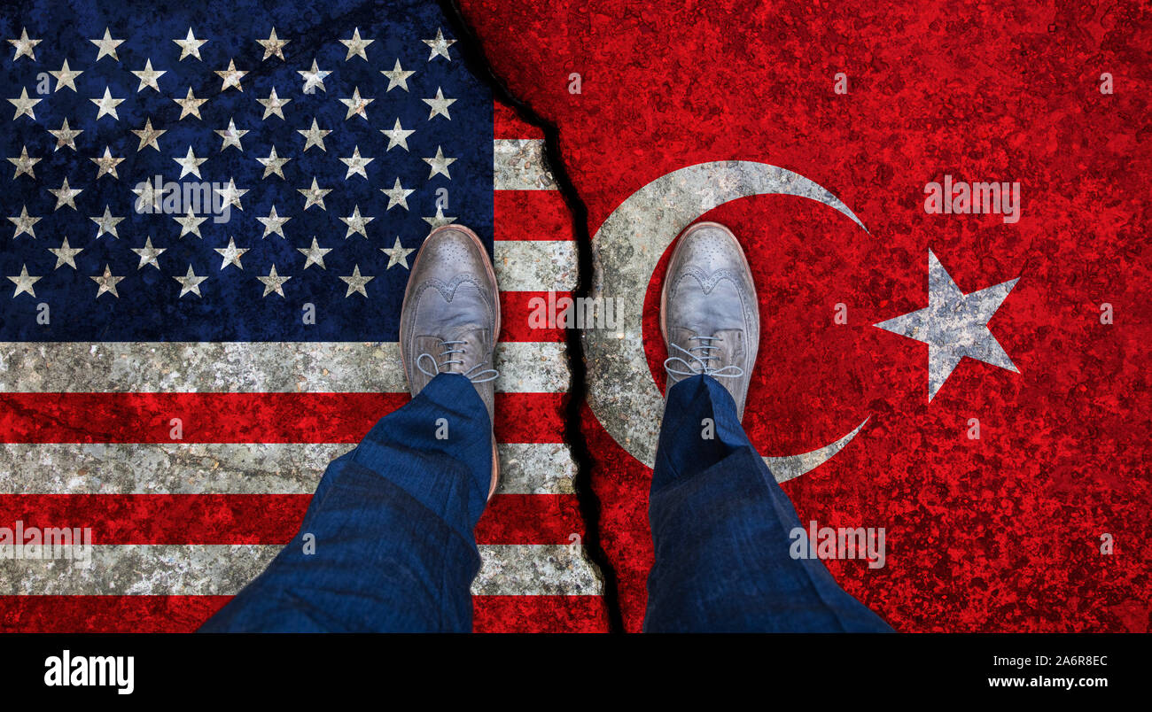 Hombre de negocios se encuentra en grietas banderas de Estados Unidos y Turquía. Concepto político Foto de stock