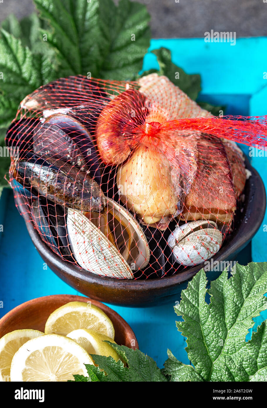 Famoso plato tradicional del sur de Chile y el archipiélago de Chiloé - el curanto al hoyo, Kuranto. Diferentes mariscos, carne y papas milcao Foto de stock