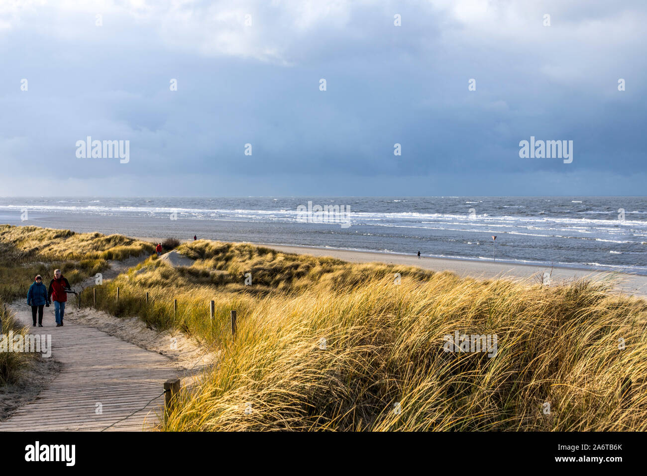 Del Mar del Norte Isla Spiekeroog, Frisia Oriental, en invierno, caminante en la beachGermany Foto de stock