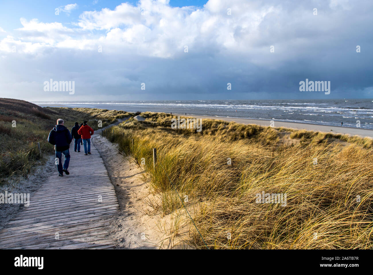 Del Mar del Norte Isla Spiekeroog, Frisia Oriental, en invierno, caminante en la beachGermany Foto de stock